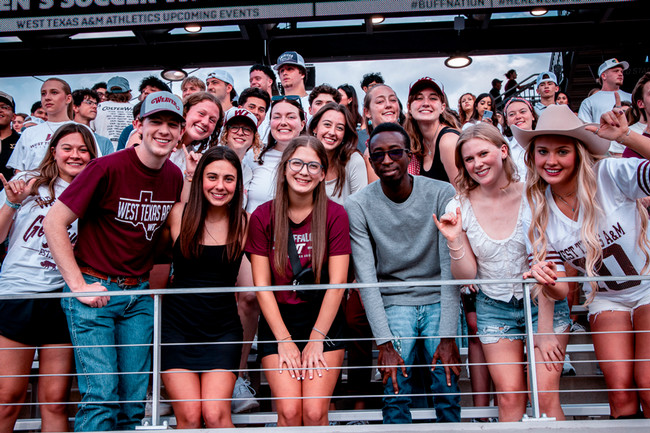 Discover WT promo students at game with cowboy hat